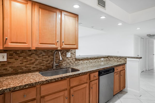 kitchen featuring sink, dark stone countertops, tasteful backsplash, light tile patterned floors, and stainless steel dishwasher