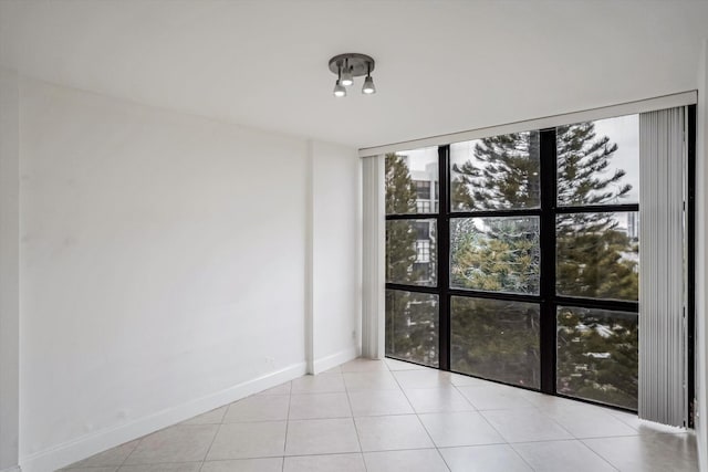 tiled spare room featuring expansive windows