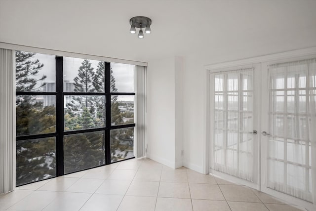 empty room with light tile patterned flooring and a wealth of natural light