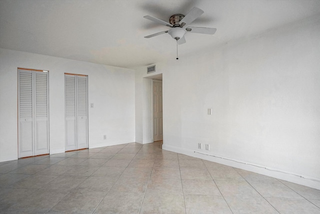 unfurnished room with ceiling fan and light tile patterned floors