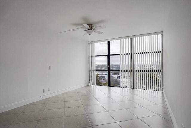 empty room with ceiling fan and light tile patterned floors