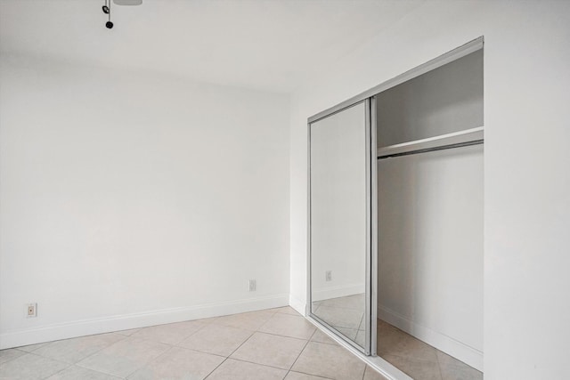 unfurnished bedroom with a closet and light tile patterned floors