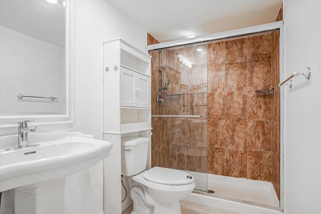 bathroom featuring toilet, an enclosed shower, and sink