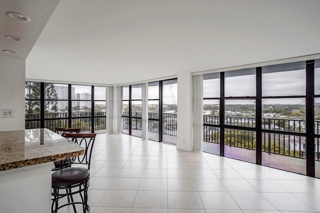 tiled living room featuring expansive windows