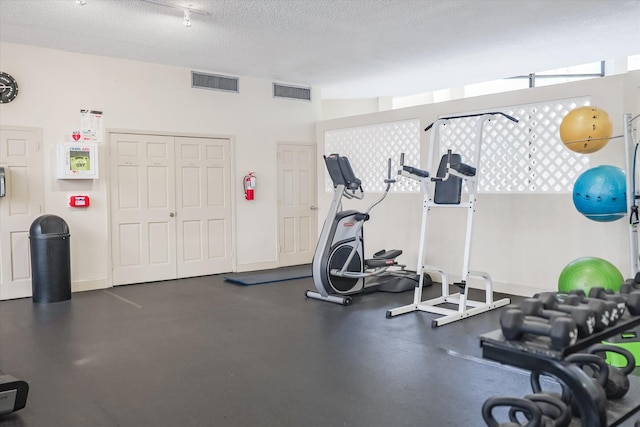 exercise room featuring a textured ceiling