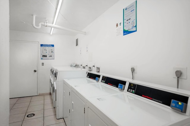 washroom featuring light tile patterned floors and washer and clothes dryer