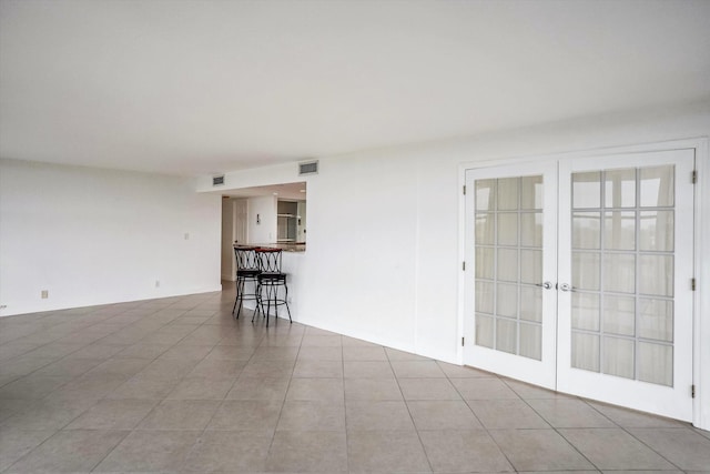 unfurnished room with french doors and light tile patterned flooring