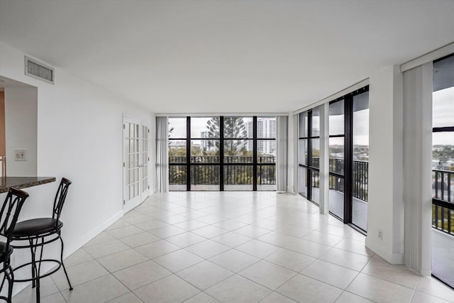 empty room with light tile patterned flooring and expansive windows