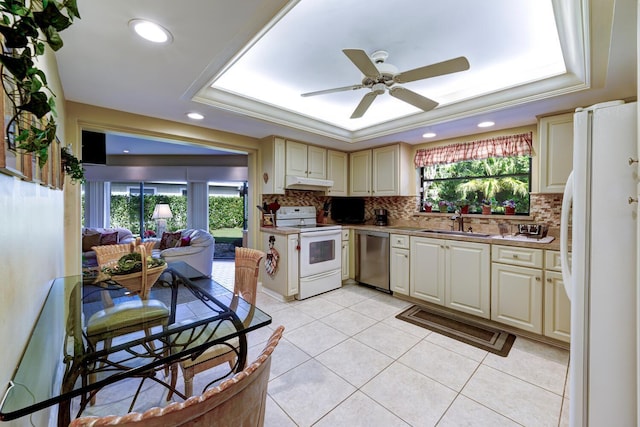 kitchen with white appliances, ceiling fan, cream cabinetry, and a tray ceiling