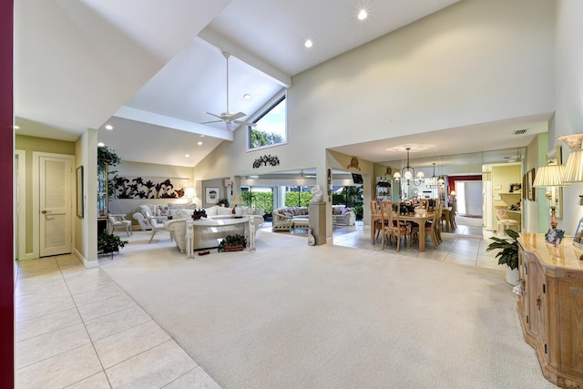 living room featuring ceiling fan with notable chandelier, high vaulted ceiling, and light carpet