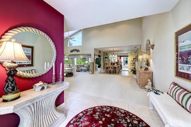 tiled entrance foyer with a healthy amount of sunlight, a notable chandelier, and a high ceiling