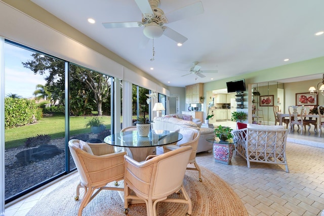 interior space featuring ceiling fan with notable chandelier