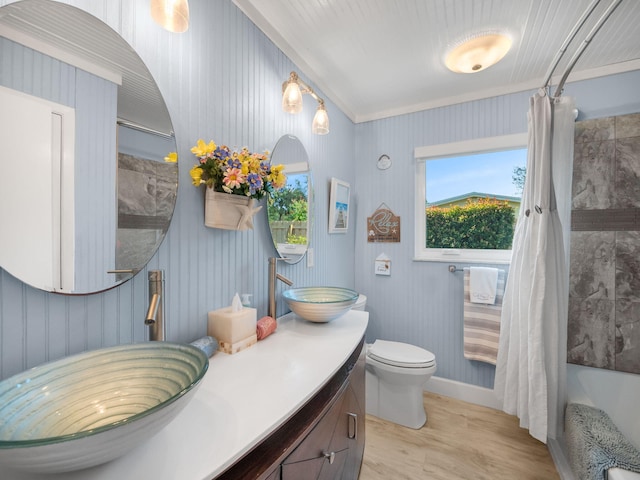 full bathroom with crown molding, toilet, vanity, shower / tub combo, and hardwood / wood-style flooring