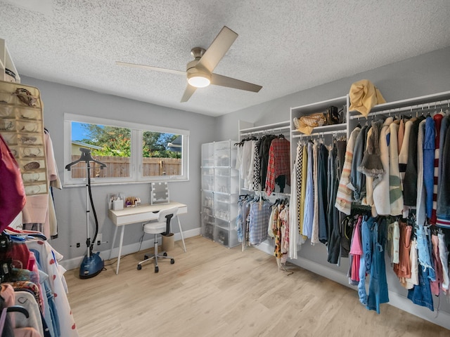 spacious closet with ceiling fan and light hardwood / wood-style flooring