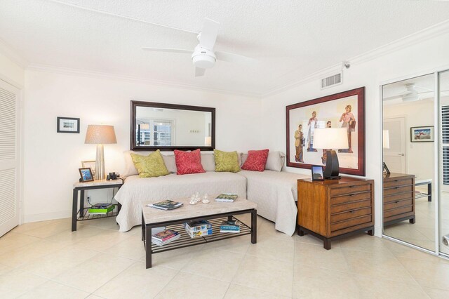 tiled living room featuring ceiling fan, crown molding, and a textured ceiling