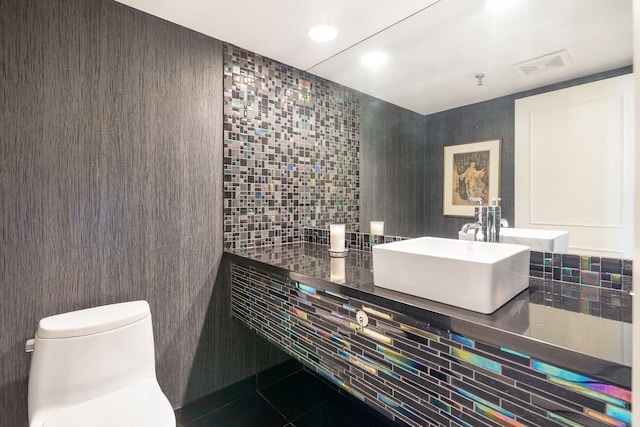 bathroom with tile walls, sink, tile patterned floors, and toilet