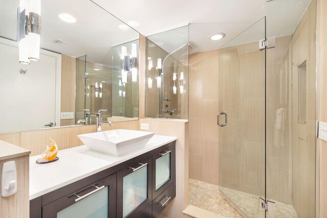 bathroom featuring vanity and a shower with shower door