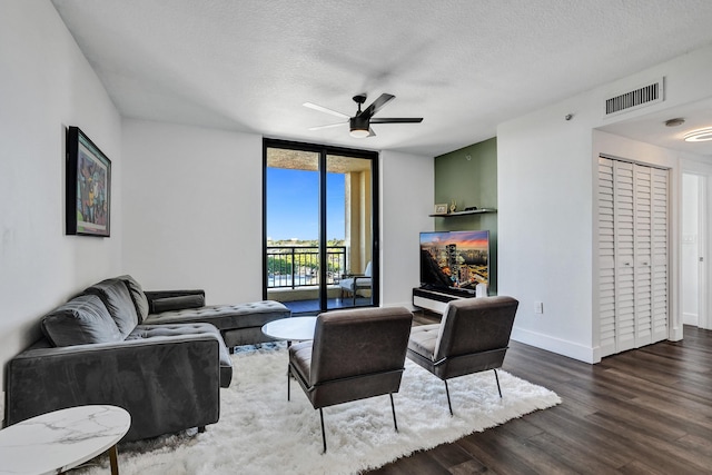 living room featuring floor to ceiling windows, a textured ceiling, dark hardwood / wood-style floors, and ceiling fan