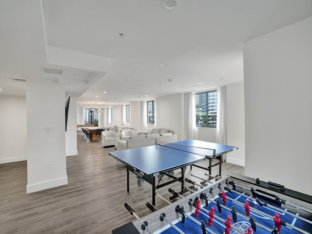 rec room featuring hardwood / wood-style flooring and a chandelier