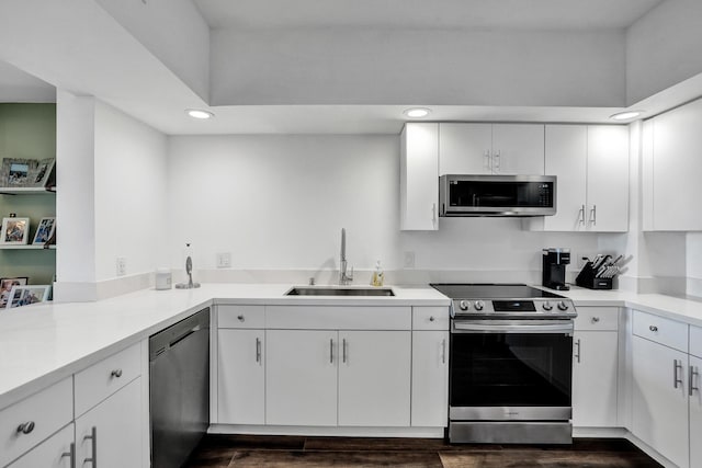 kitchen with dark hardwood / wood-style flooring, sink, white cabinets, and appliances with stainless steel finishes