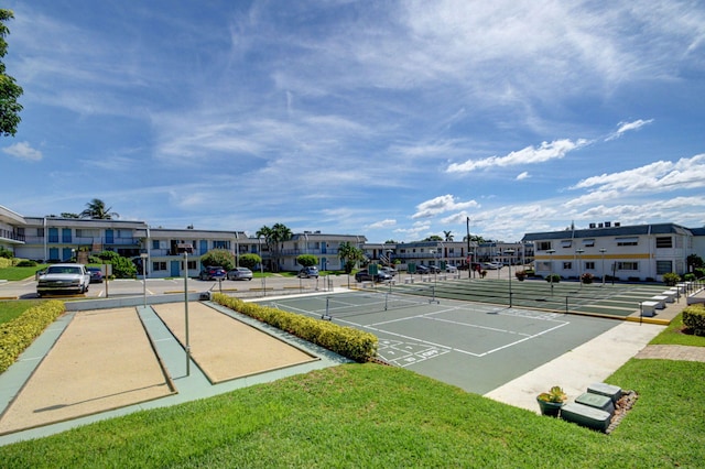 view of tennis court with a yard