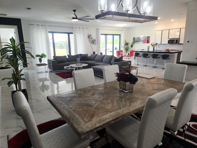 dining space featuring visible vents, marble finish floor, and ceiling fan