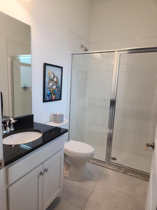 full bathroom featuring tile patterned flooring, toilet, a stall shower, and vanity