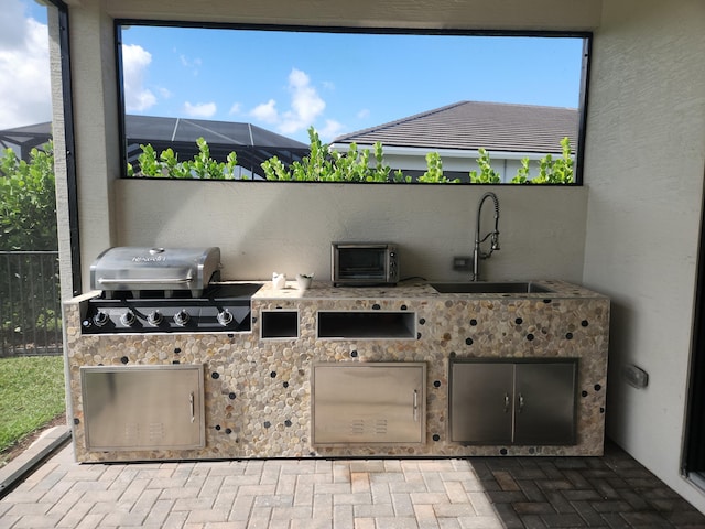 view of patio / terrace with area for grilling, sink, and glass enclosure