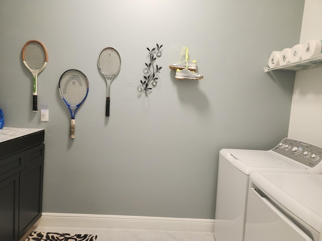 laundry room featuring washer and dryer, baseboards, cabinet space, and tile patterned floors