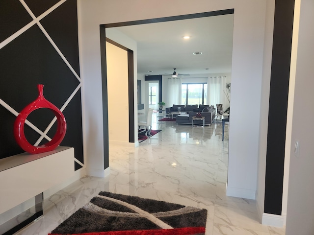 corridor with visible vents, baseboards, and marble finish floor