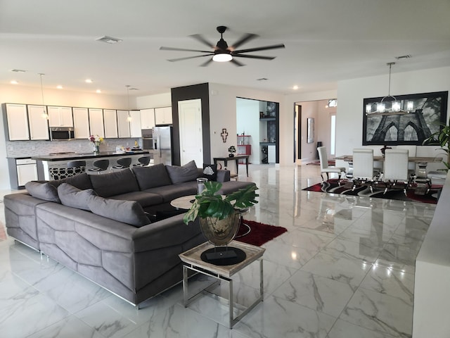 living room featuring ceiling fan with notable chandelier