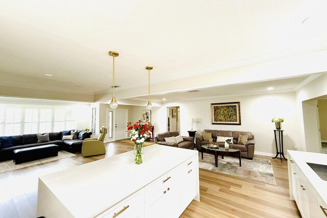 kitchen featuring appliances with stainless steel finishes, pendant lighting, white cabinetry, sink, and a center island