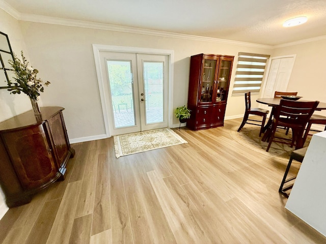 interior space with french doors, crown molding, and light wood-type flooring