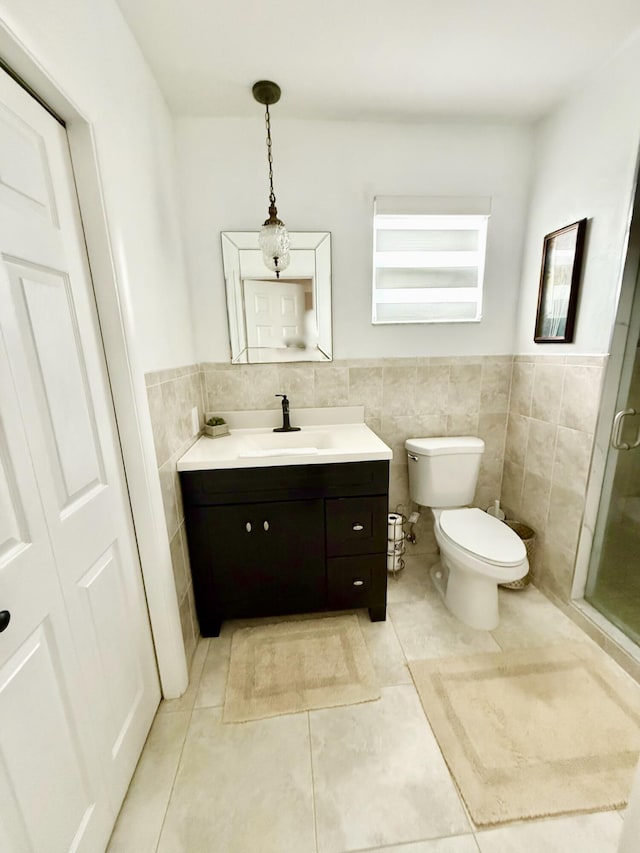 bathroom with vanity, tile walls, tile patterned floors, and toilet