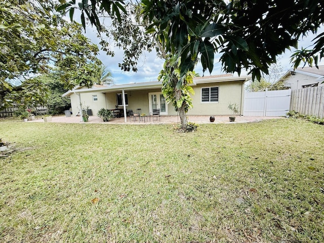 rear view of property with a yard and a patio area