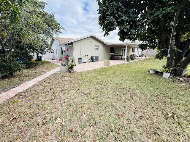 exterior space featuring a patio, central AC unit, and a lawn