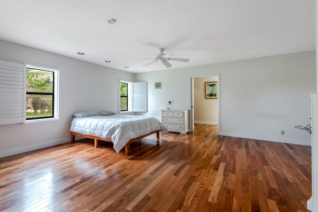 bedroom featuring ceiling fan, a textured ceiling, and hardwood / wood-style flooring