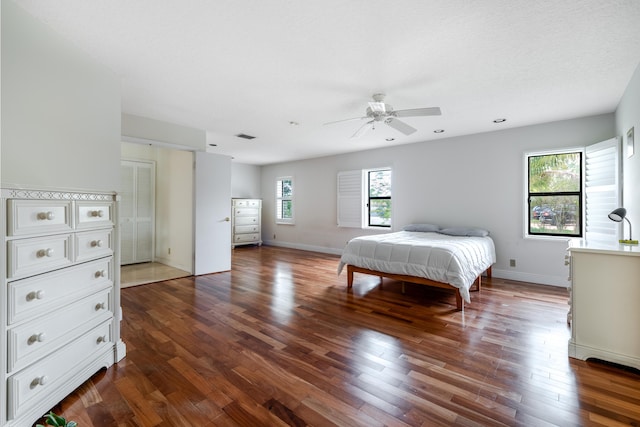 bedroom featuring ceiling fan, dark hardwood / wood-style flooring, and a textured ceiling