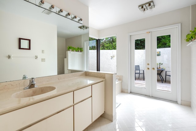 bathroom with tile patterned floors, french doors, and vanity