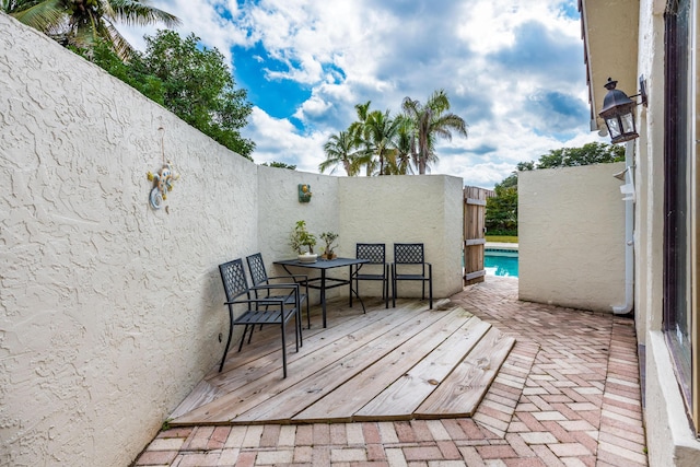 deck featuring a fenced in pool and a patio