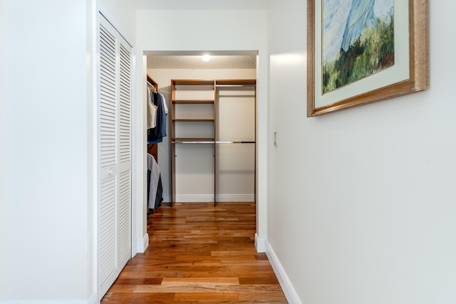 hallway featuring a textured ceiling and light wood-type flooring