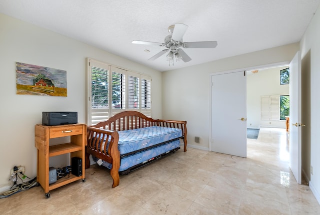 bedroom featuring a textured ceiling and ceiling fan