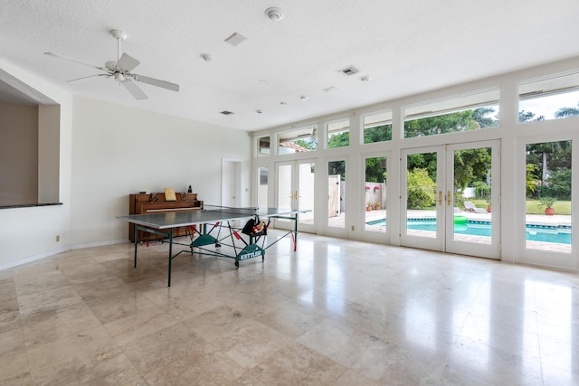 recreation room featuring ceiling fan, a textured ceiling, and french doors