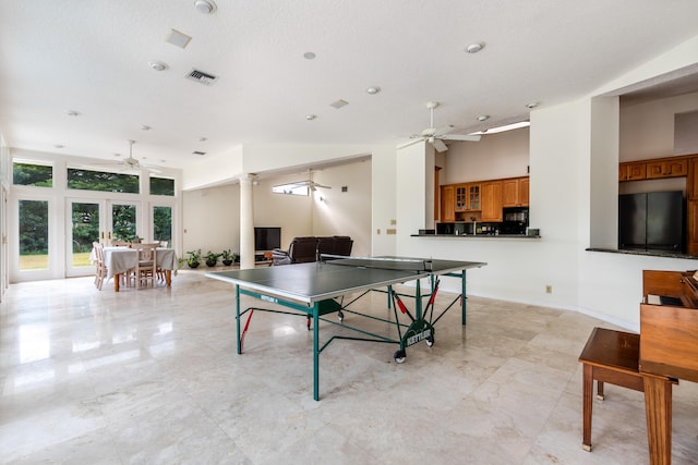 recreation room with french doors, decorative columns, a textured ceiling, ceiling fan, and high vaulted ceiling