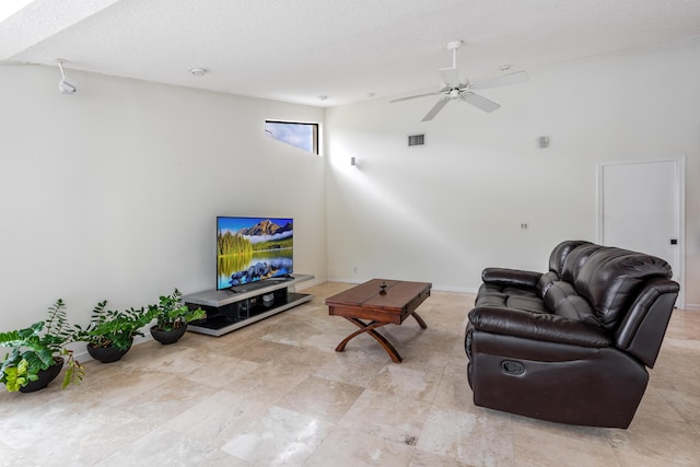 living room featuring a textured ceiling and ceiling fan