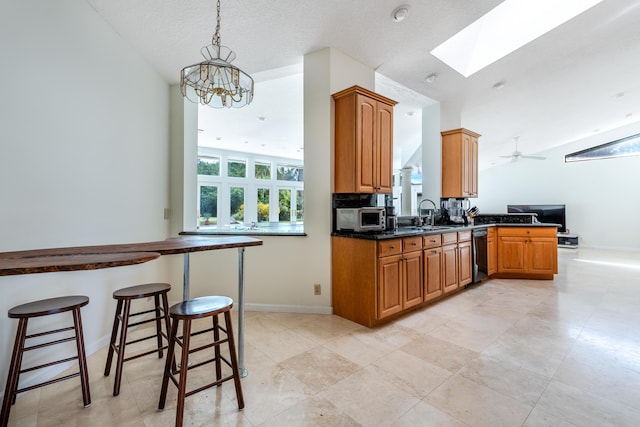 kitchen with ceiling fan with notable chandelier, sink, a textured ceiling, decorative light fixtures, and kitchen peninsula