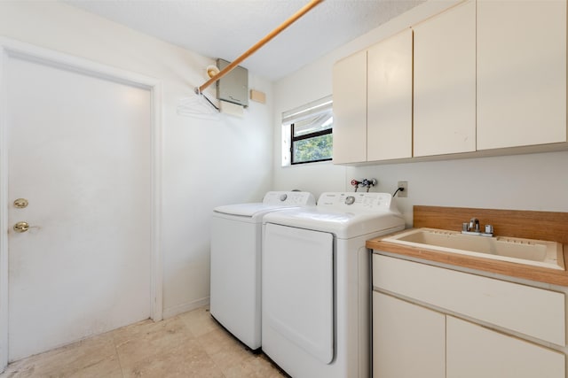 washroom with washer and dryer, sink, and cabinets