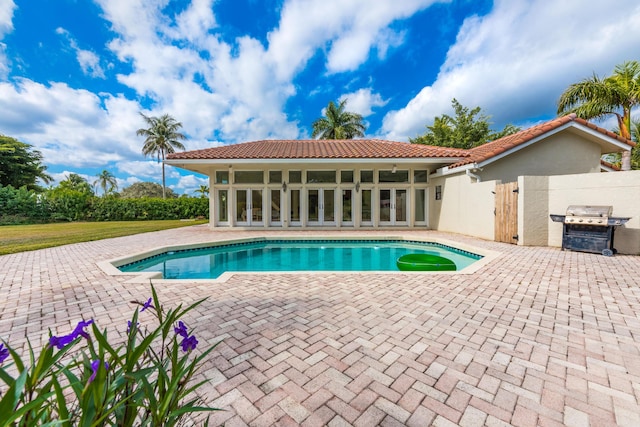 view of pool featuring area for grilling and a patio area