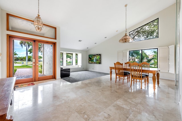 dining room featuring french doors, a towering ceiling, and an inviting chandelier