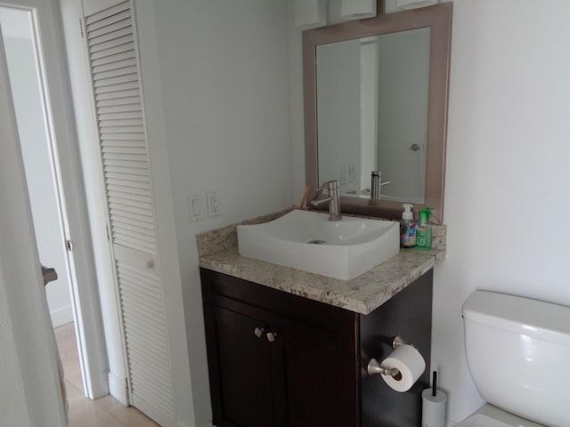 bathroom featuring tile patterned flooring, vanity, and toilet